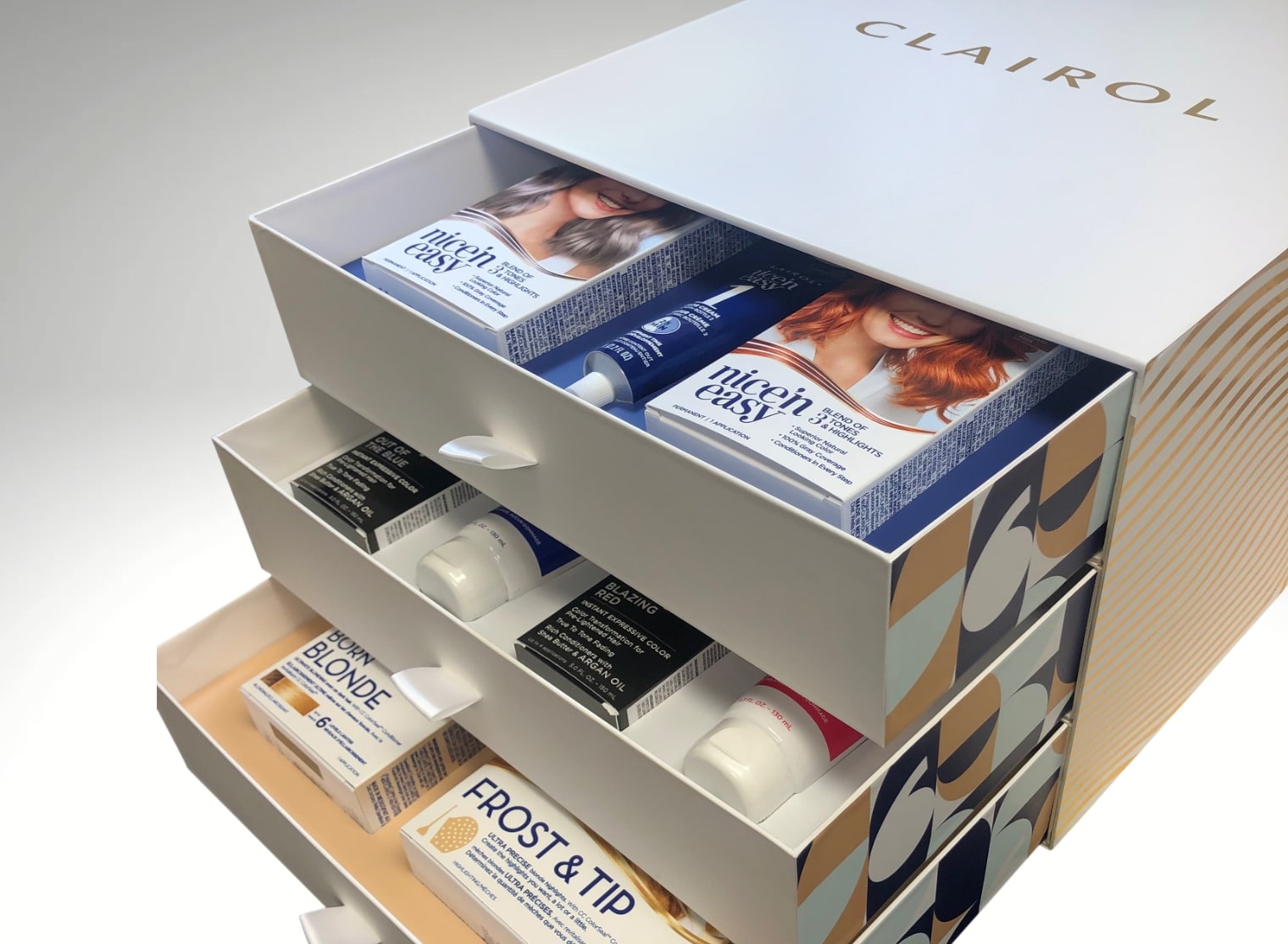 An open drawer unit labeled "Clairol" reveals various hair dye kits, including "Nice‘n Easy", "Frost & Tip", and "Born Blonde". Imagine incorporating small format printing on the packaging for a more personalized touch.