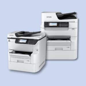 Two white Epson multifunction printers with digital displays are positioned side by side against a light blue background.