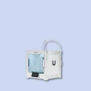 A white Ultimaker 3D printer with a transparent blue door is shown against a plain light blue background.